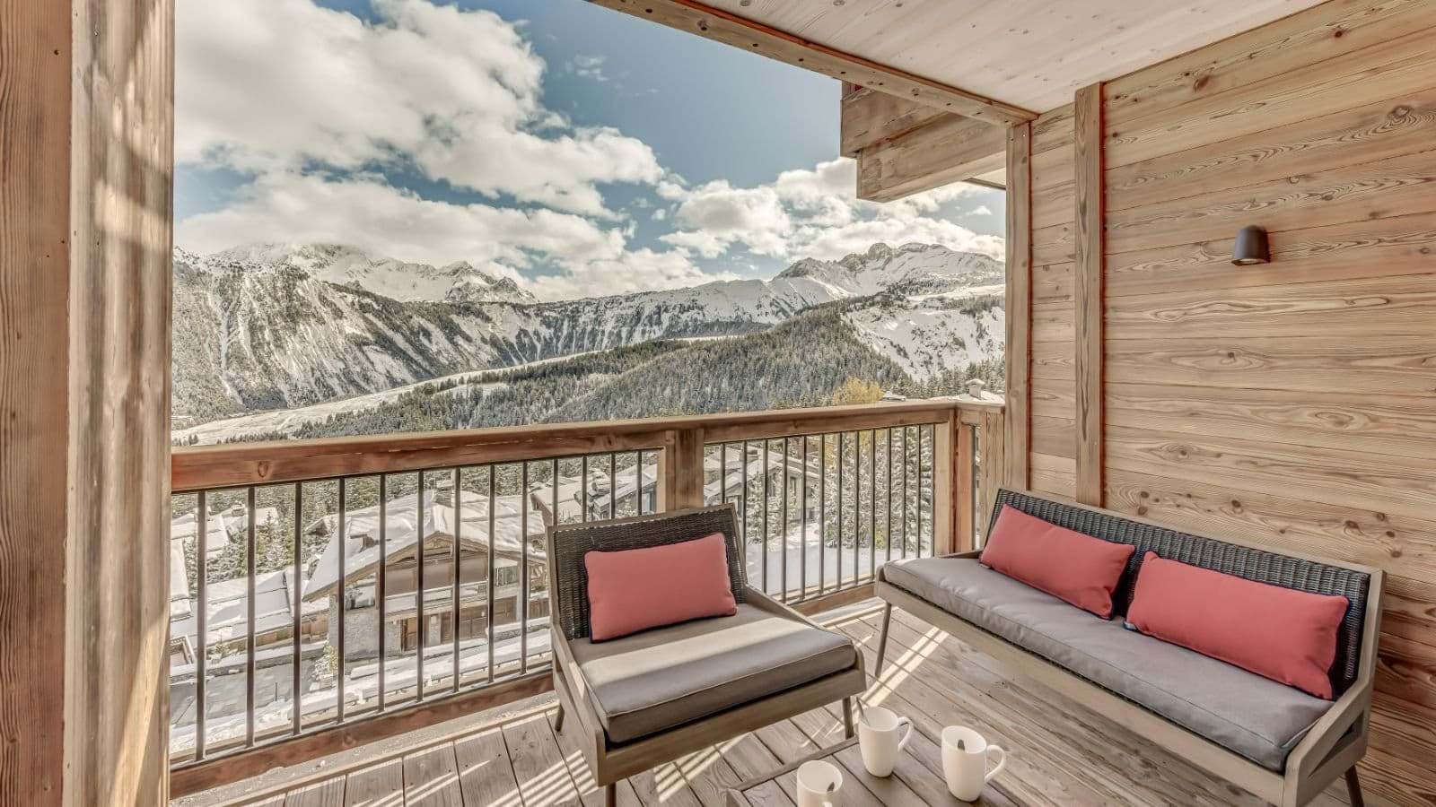 Covered private balcony with lounge seating and panoramic alpine views