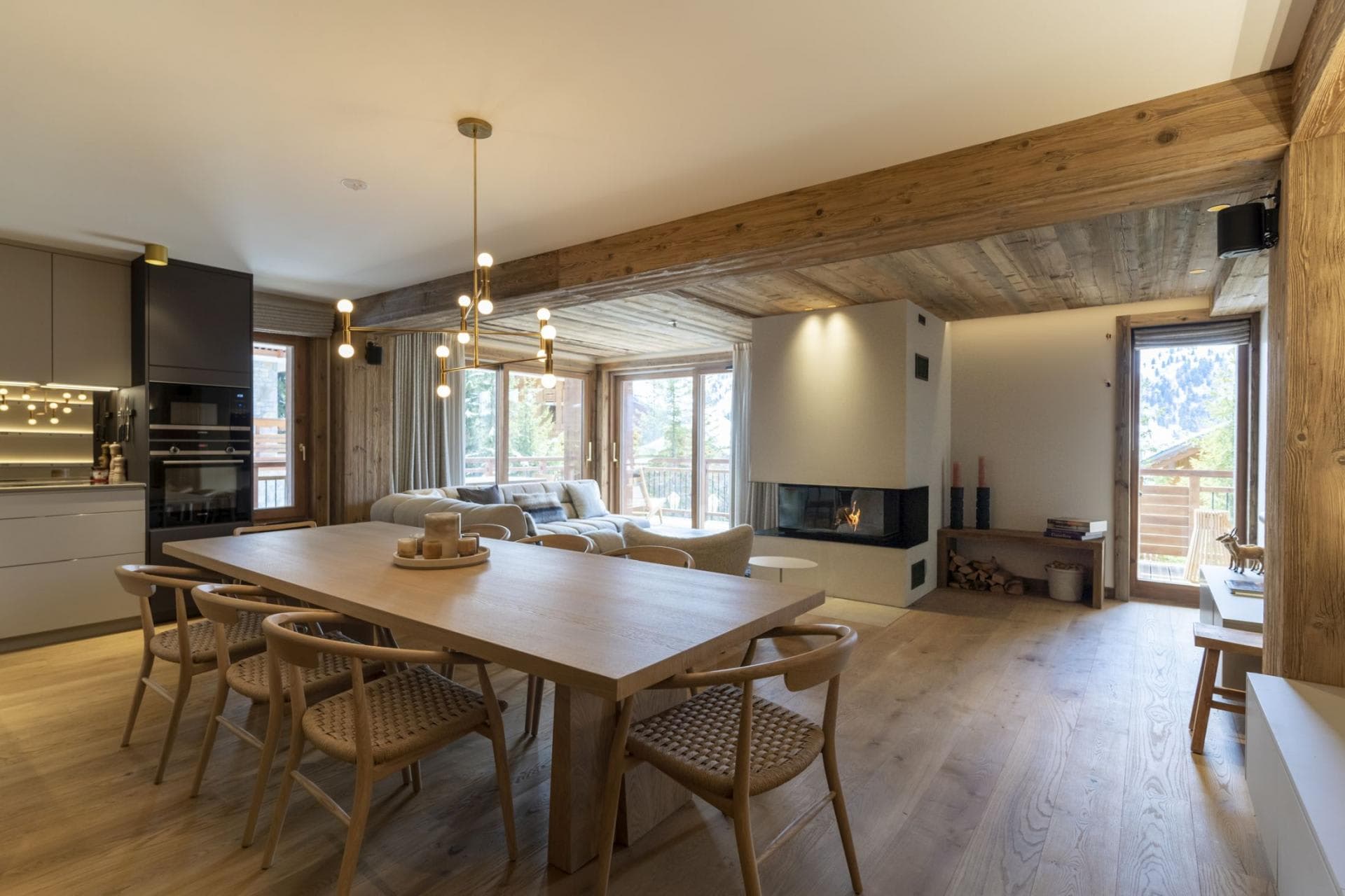Open-plan dining area seating 8 with wood-burning fireplace and balcony access
