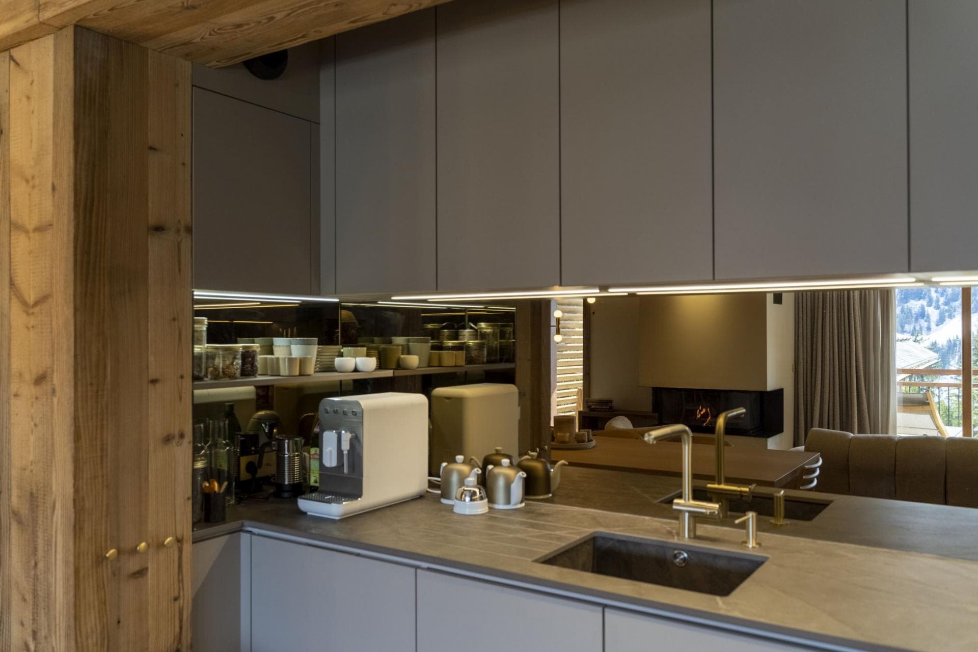 Kitchen coffee station with Smeg espresso machine and mirrored backsplash