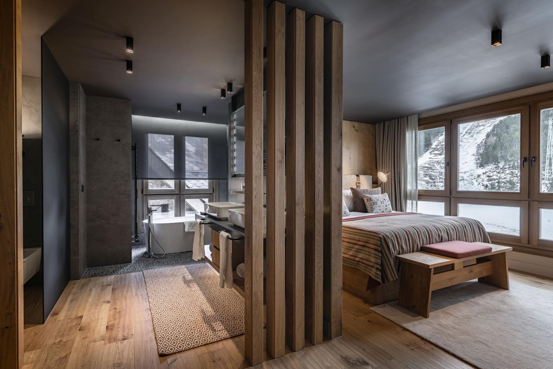 Primary suite with open-plan bathroom, soaking tub, and mountain views