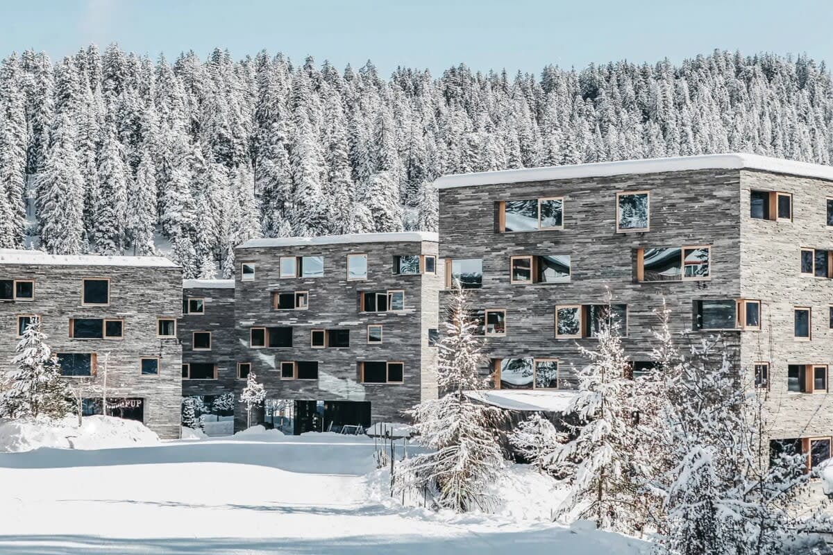 Stone facade apartment complex with ski-in/ski-out access and forest views