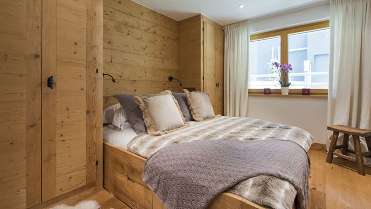 Guest bedroom with queen bed and built-in wood wardrobes
