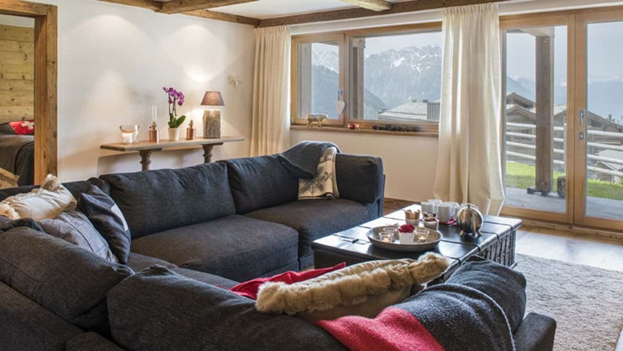 Living area with sectional seating and balcony access to mountain views