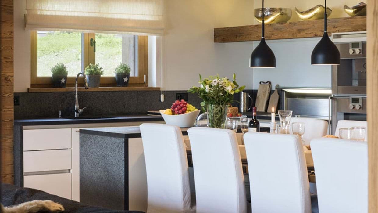 Kitchen with stone countertops, double wall ovens, and breakfast bar seating