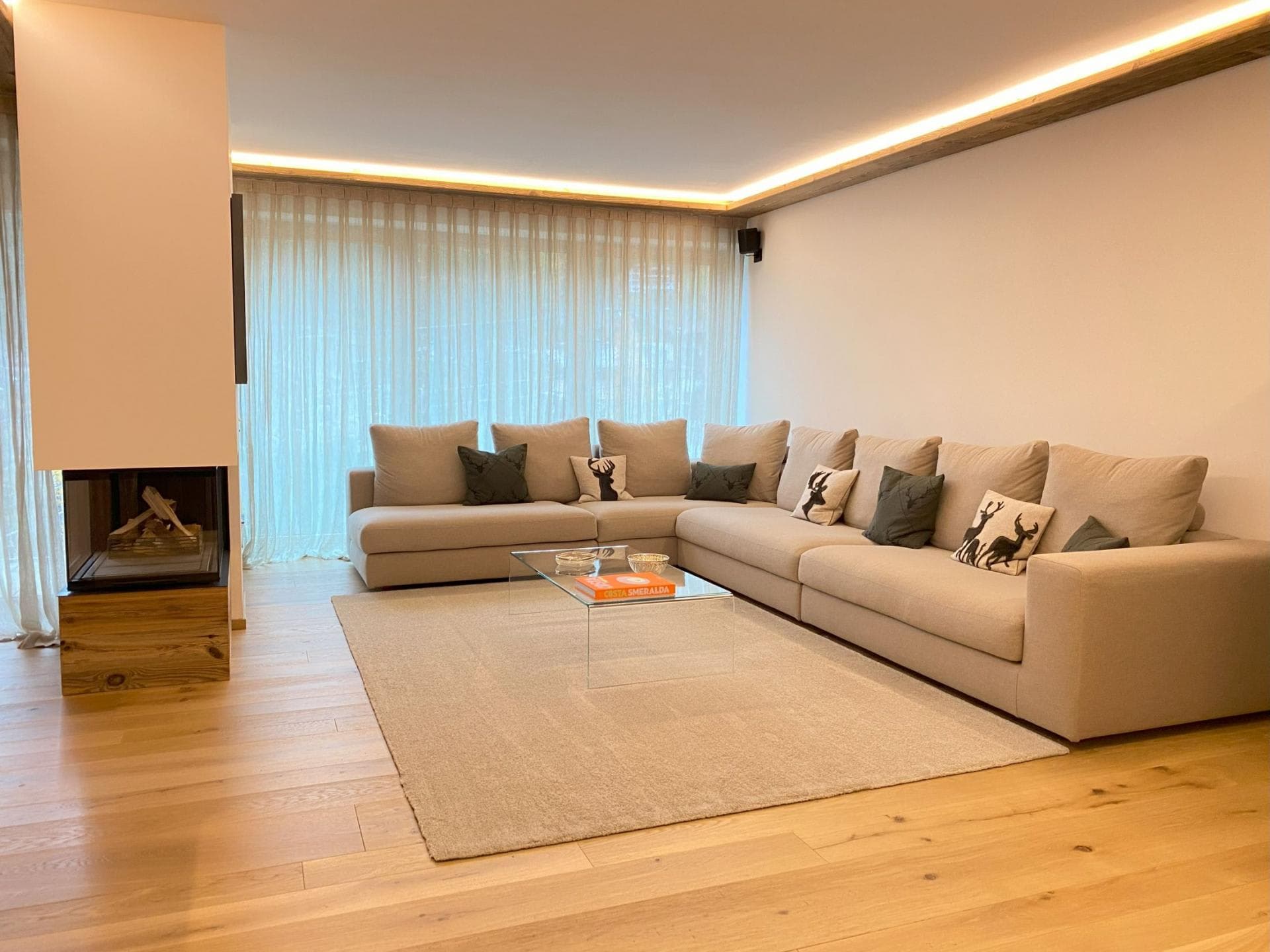 Living area with corner wood-burning fireplace and sectional seating for 8