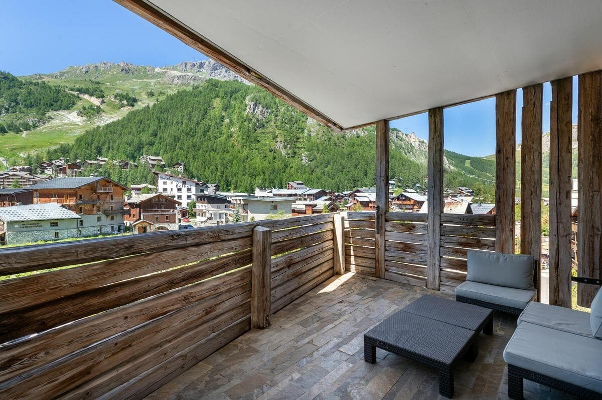 Covered balcony with lounge seating and mountain village views