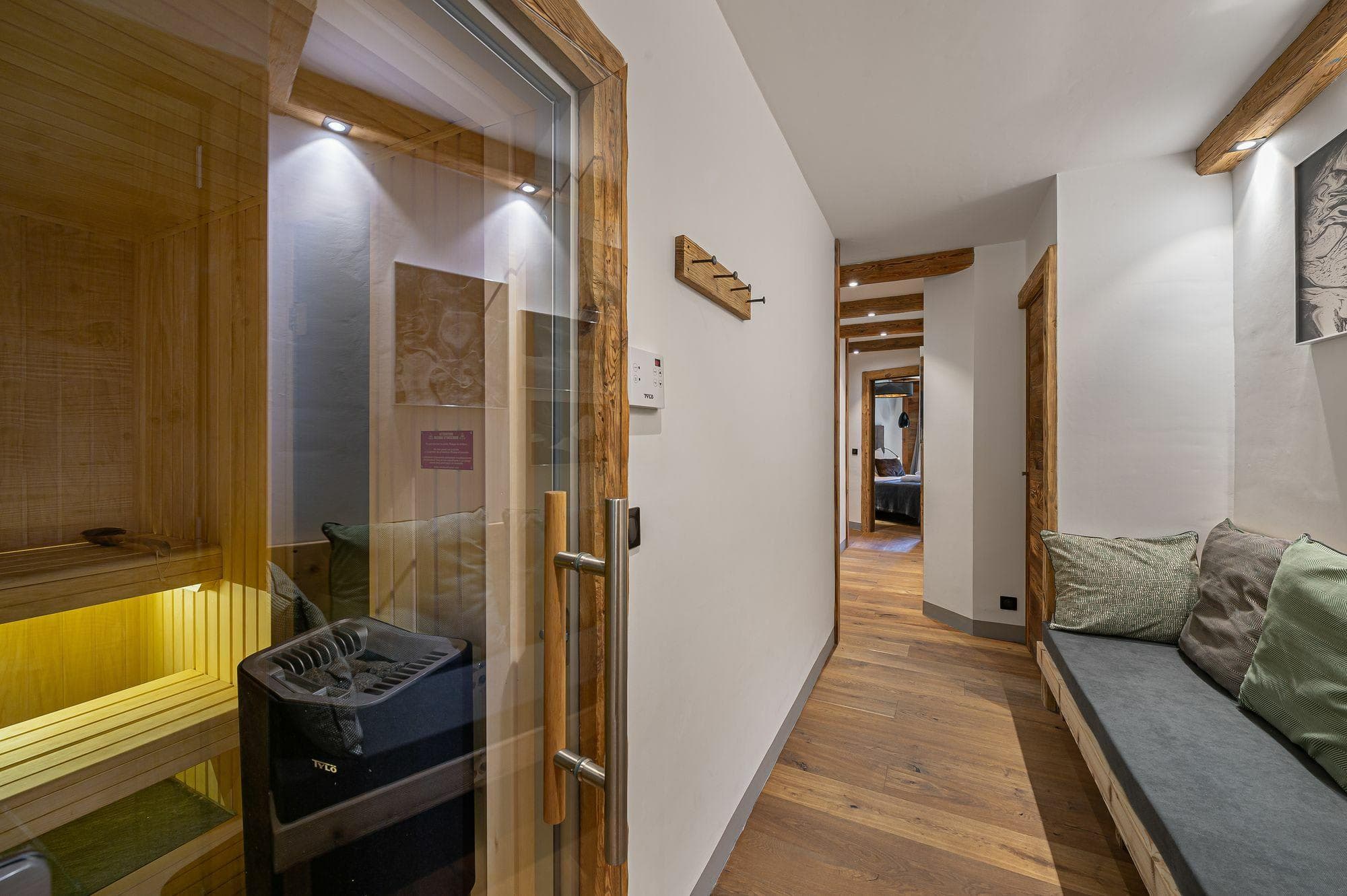 Private sauna and relaxation bench located in lower level hallway