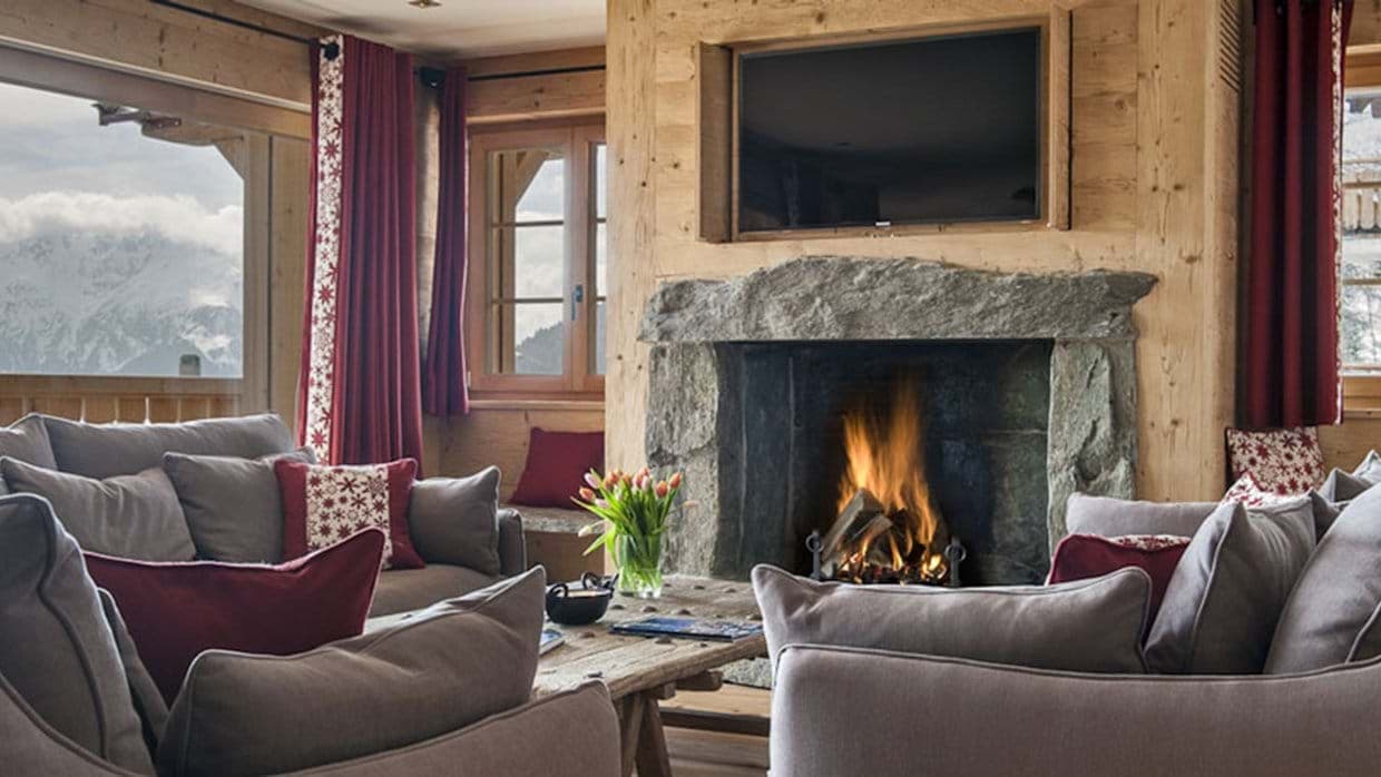 Living area with wood-burning stone fireplace and mountain views