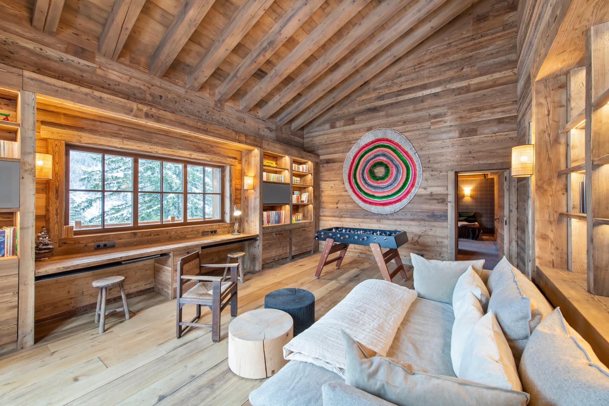 Family room with foosball table, library wall, and built-in workspace