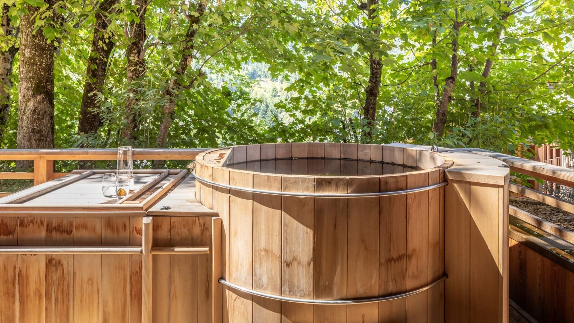 Cedar wood-fired hot tub on private deck with forest view