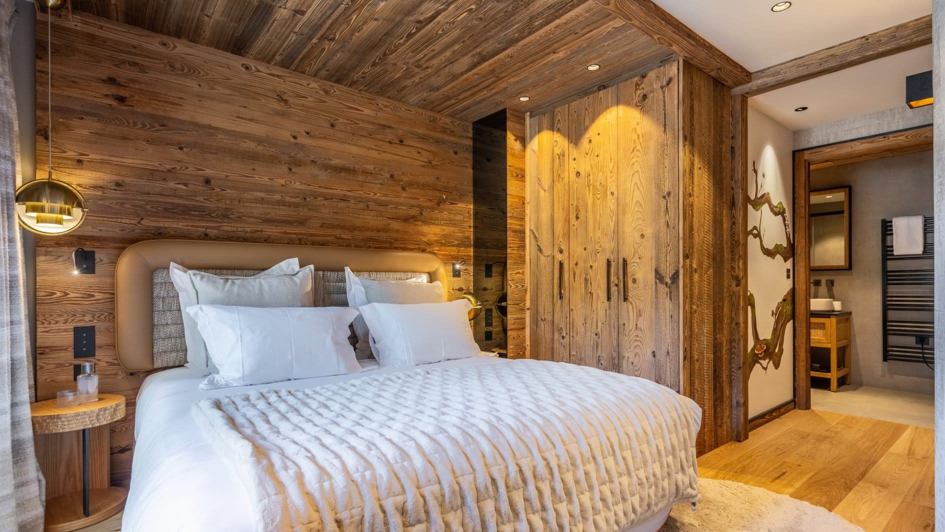 Primary bedroom with reclaimed wood walls and ensuite bathroom access