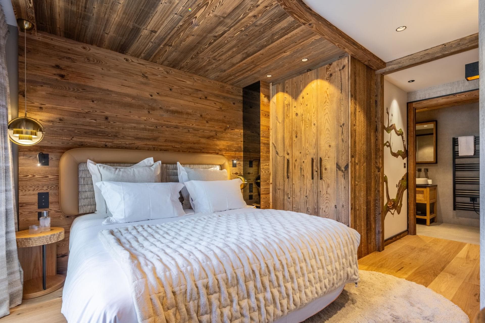 Bedroom with queen bed, reclaimed wood paneling, and ensuite bathroom