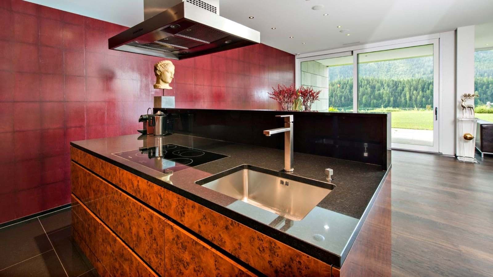 Kitchen island with induction cooktop and forest-view sliding doors