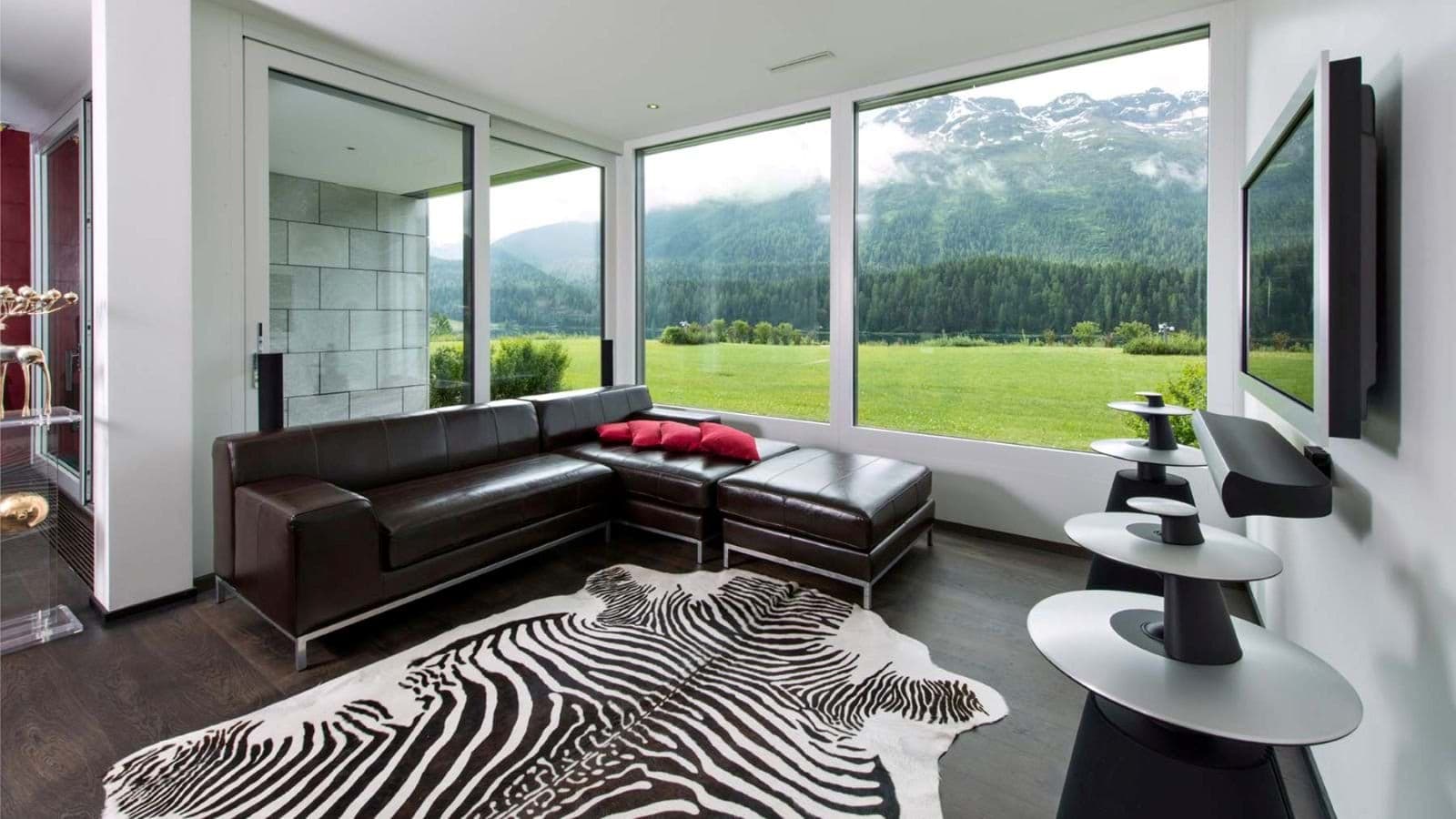 Media room with leather sectional, surround sound, and floor-to-ceiling mountain views
