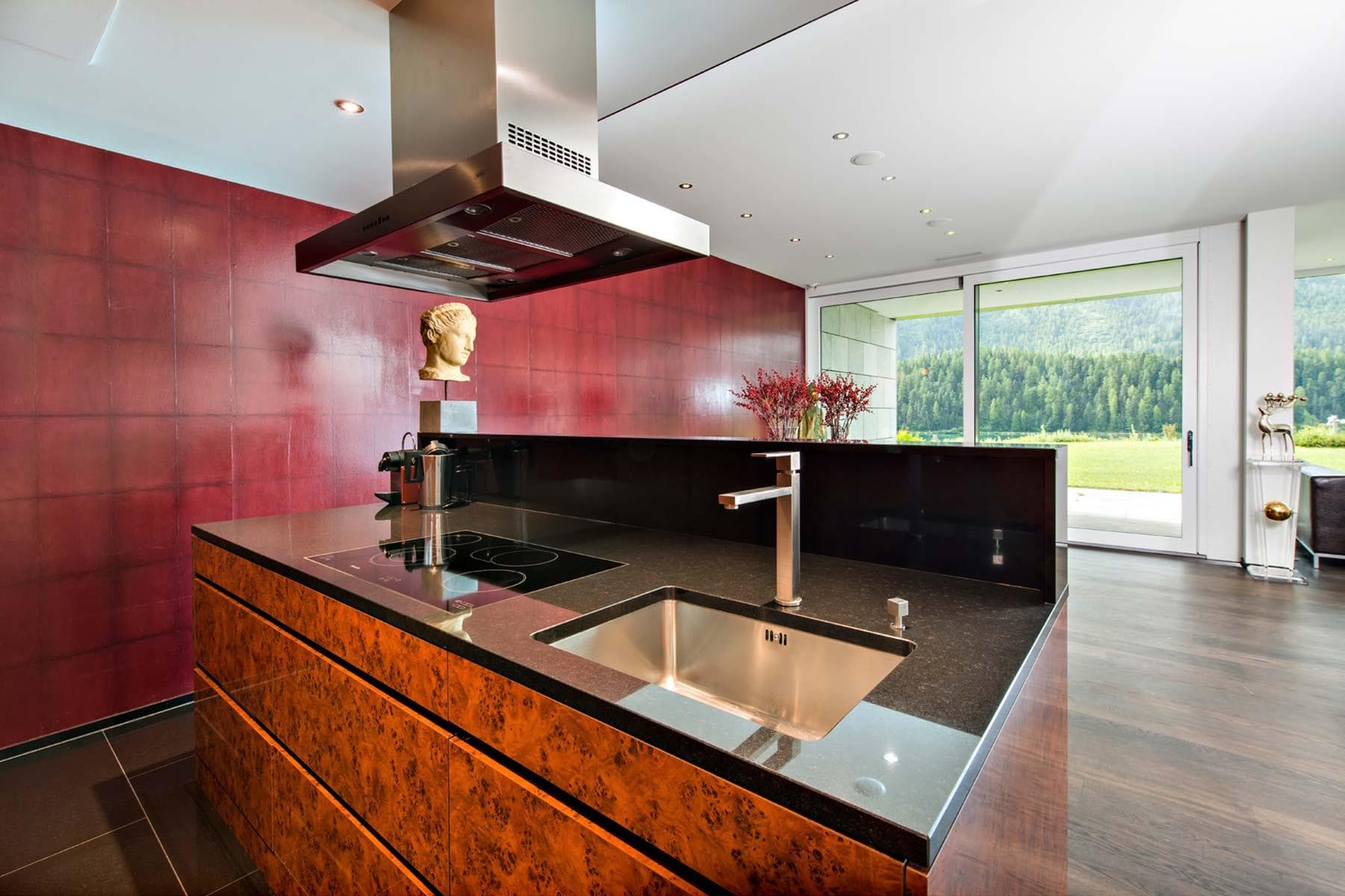 Kitchen island with induction cooktop and forest views