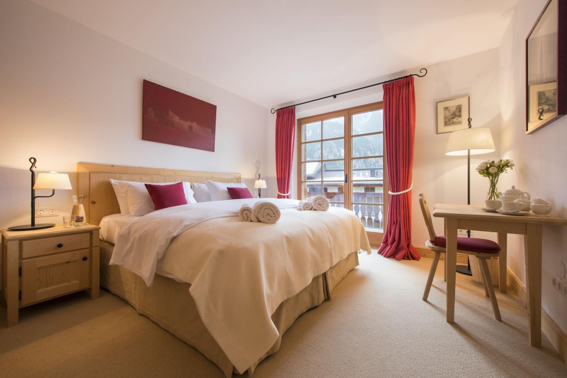 Guest bedroom with king bed, desk, and balcony access