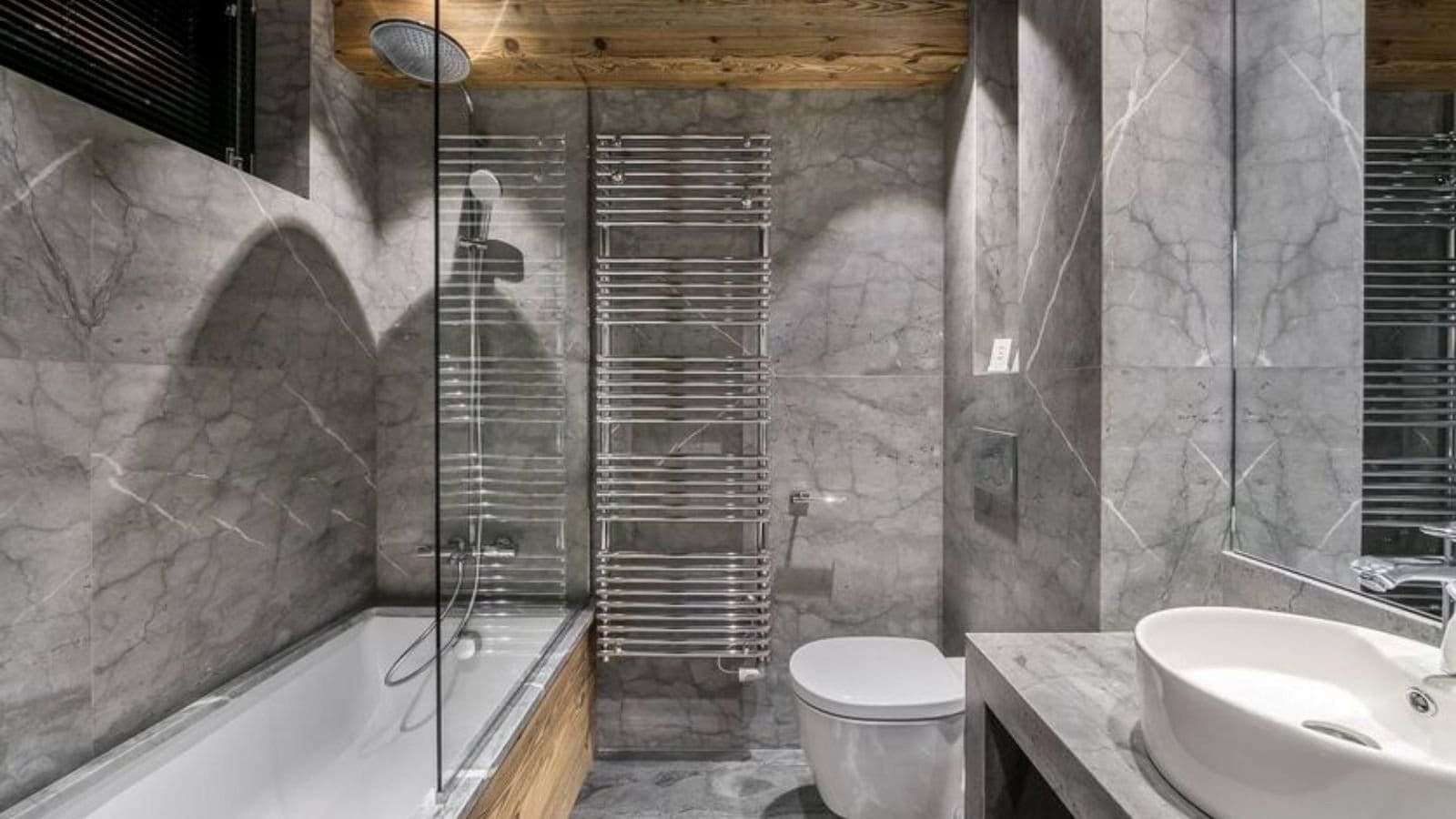 Bathroom with rainfall shower, soaking tub, and heated towel rack