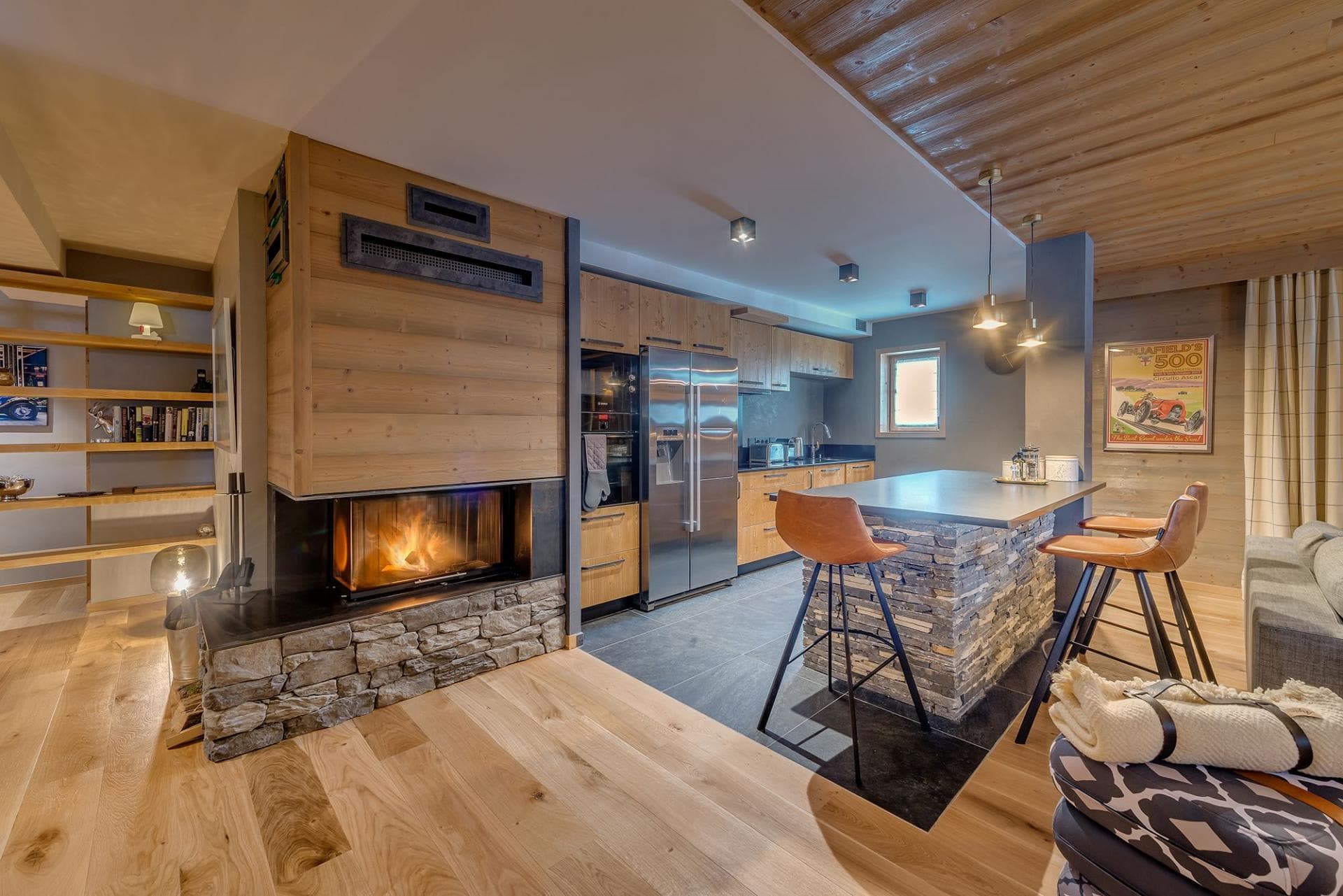 Open-plan kitchen with stone island and wood-burning fireplace