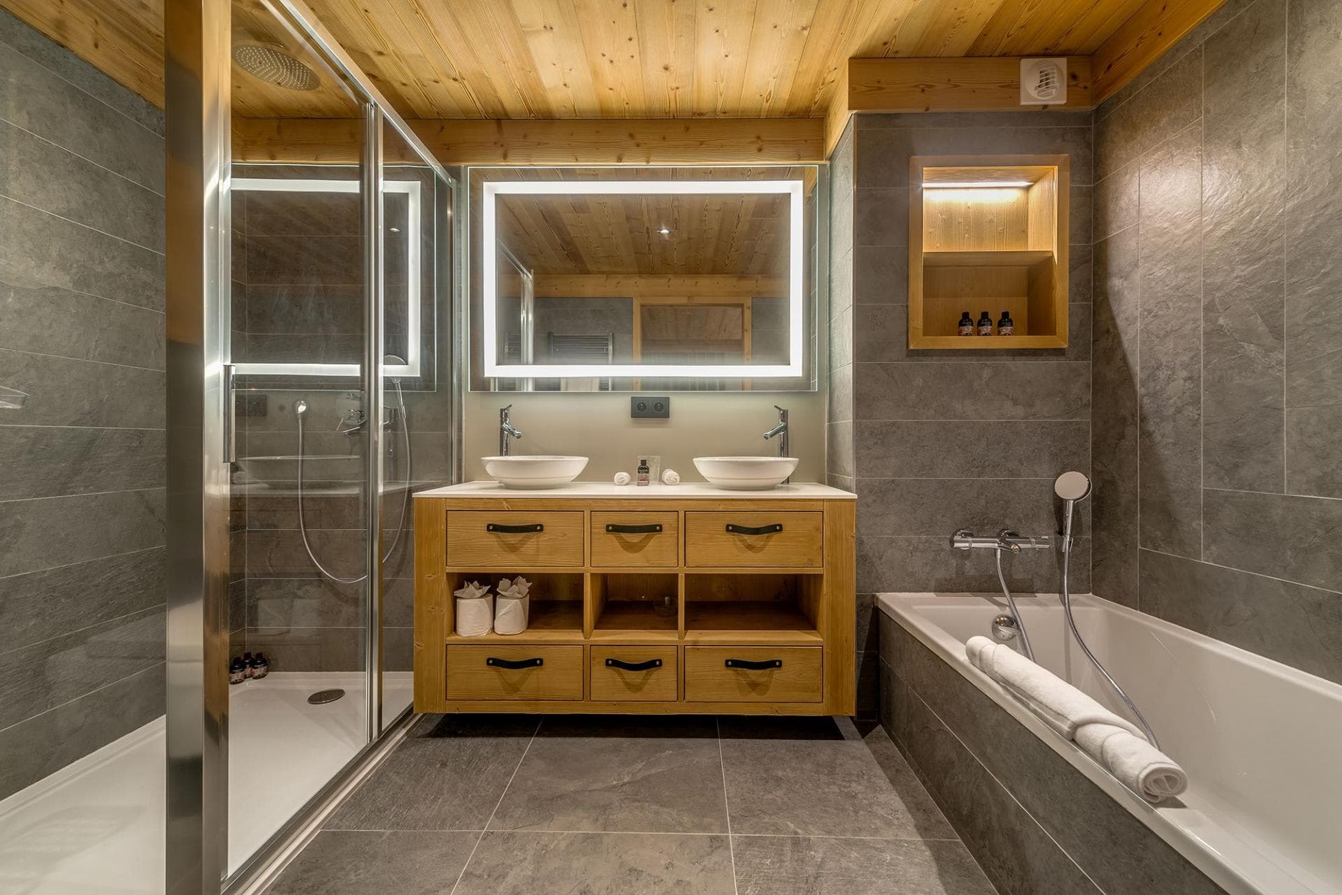 Bathroom with dual vessel sinks, walk-in rainfall shower, and separate soaking tub