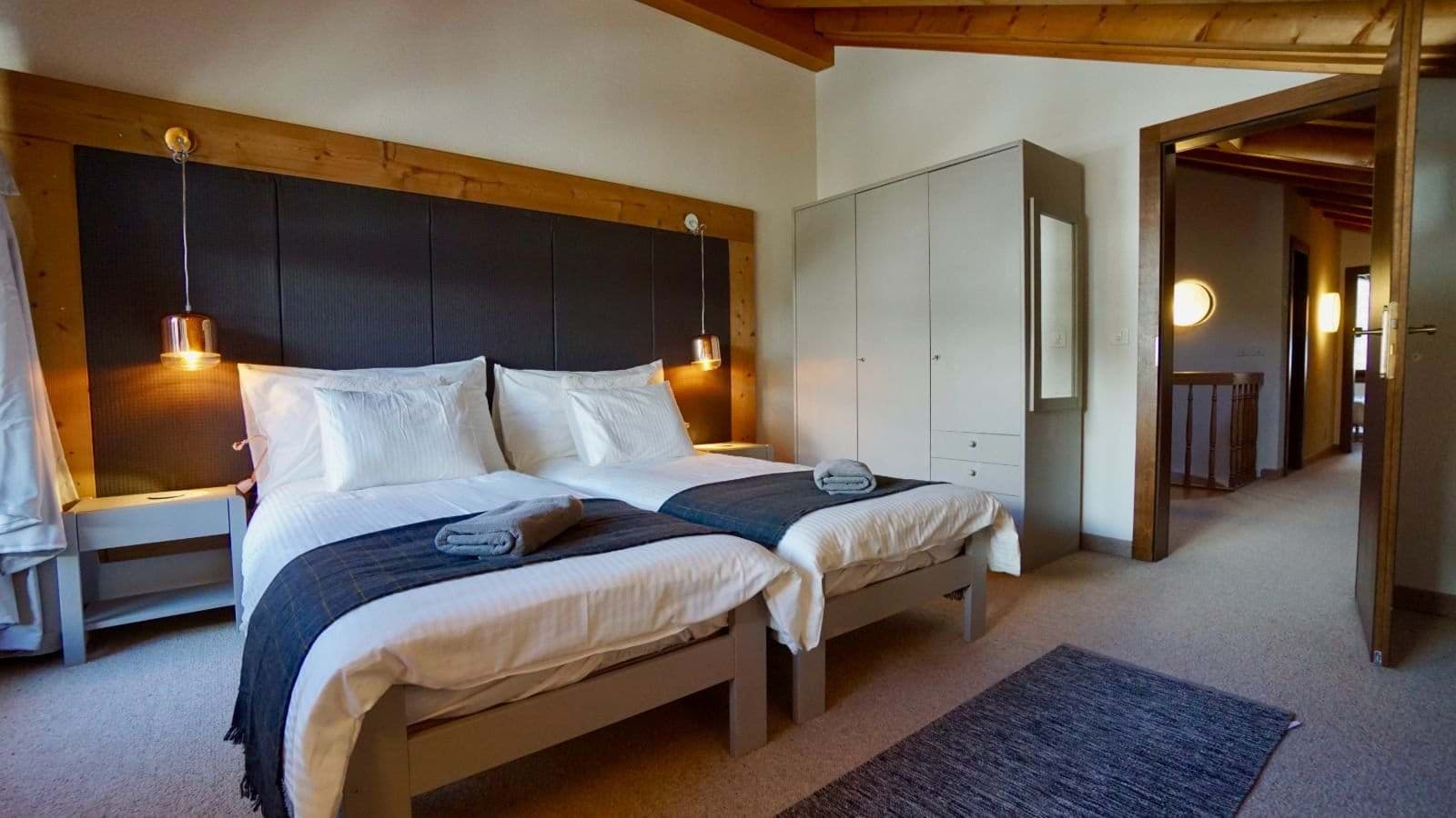 Guest bedroom with two twin beds and dedicated wardrobe storage