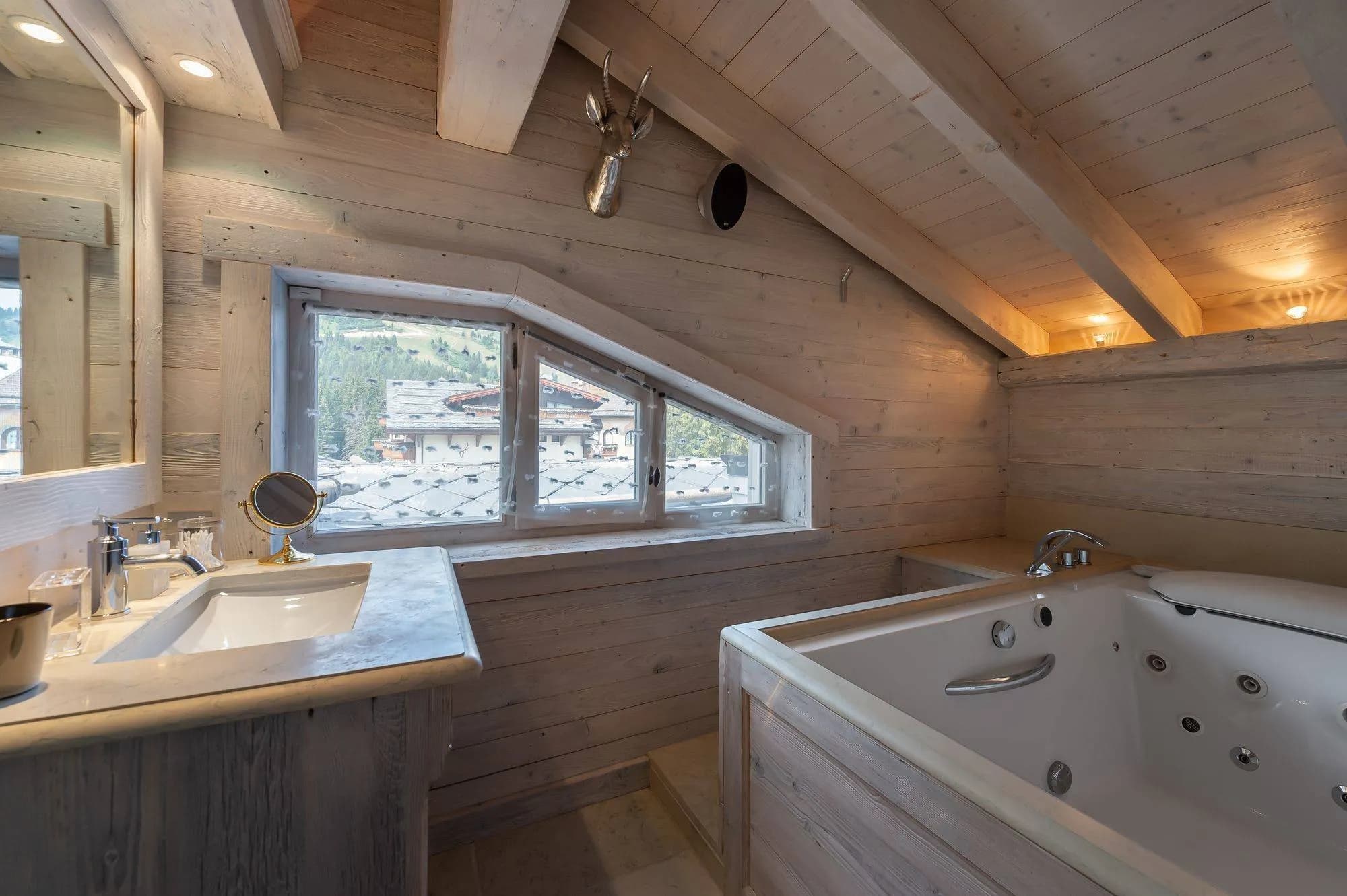 Whirlpool bath and twin basins beneath a timber ceiling