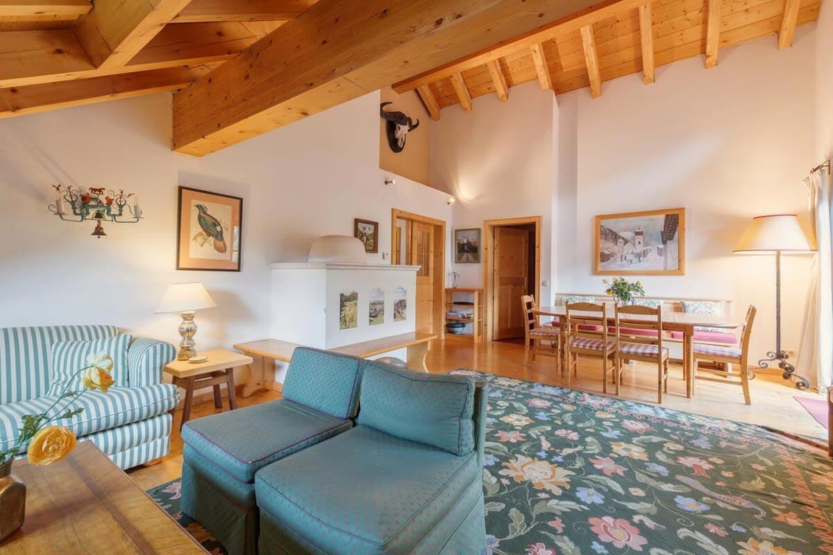 Open-plan living area with vaulted timber ceilings and dining seating for 6