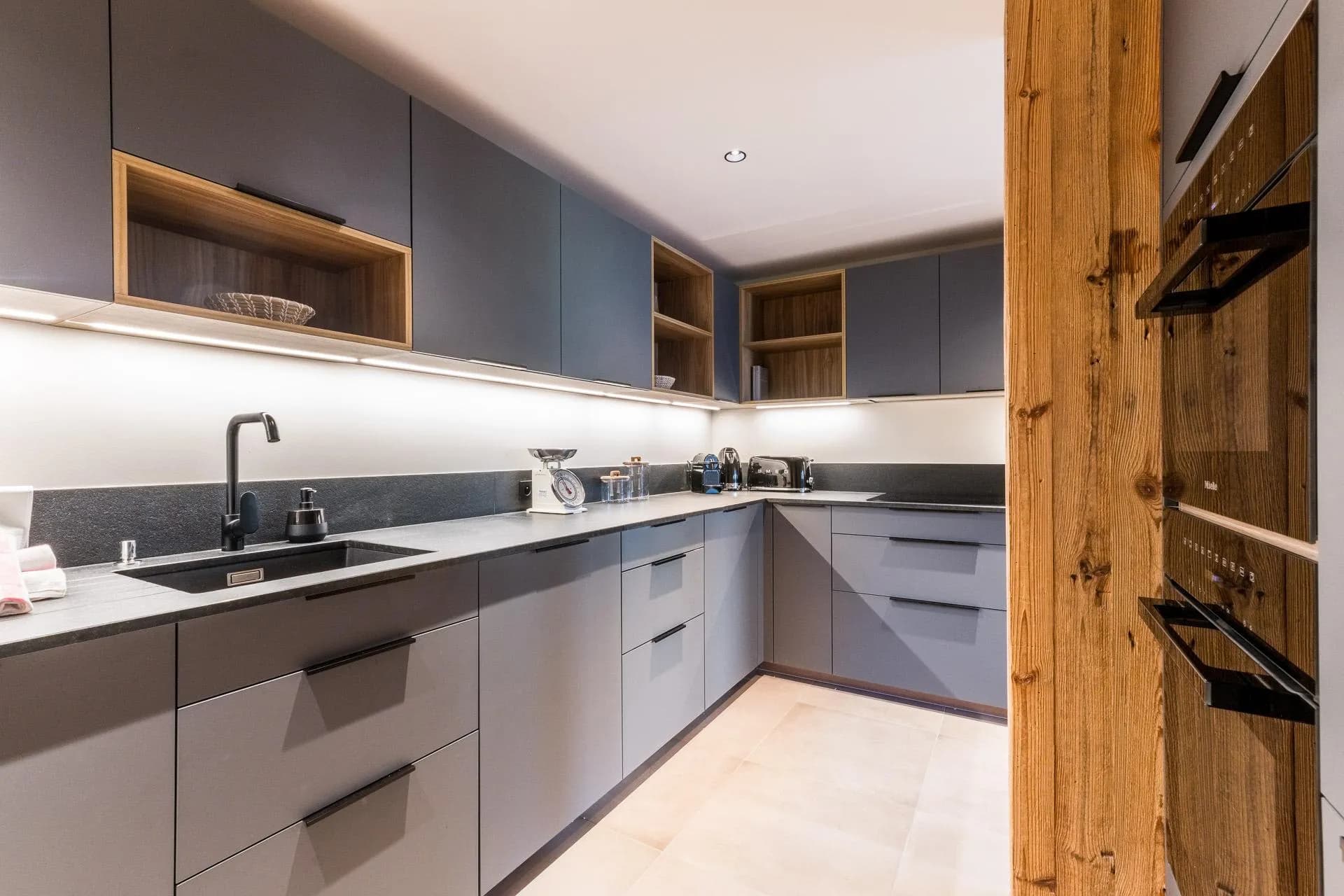 Fitted kitchen with built-in ovens and under-cabinet lighting