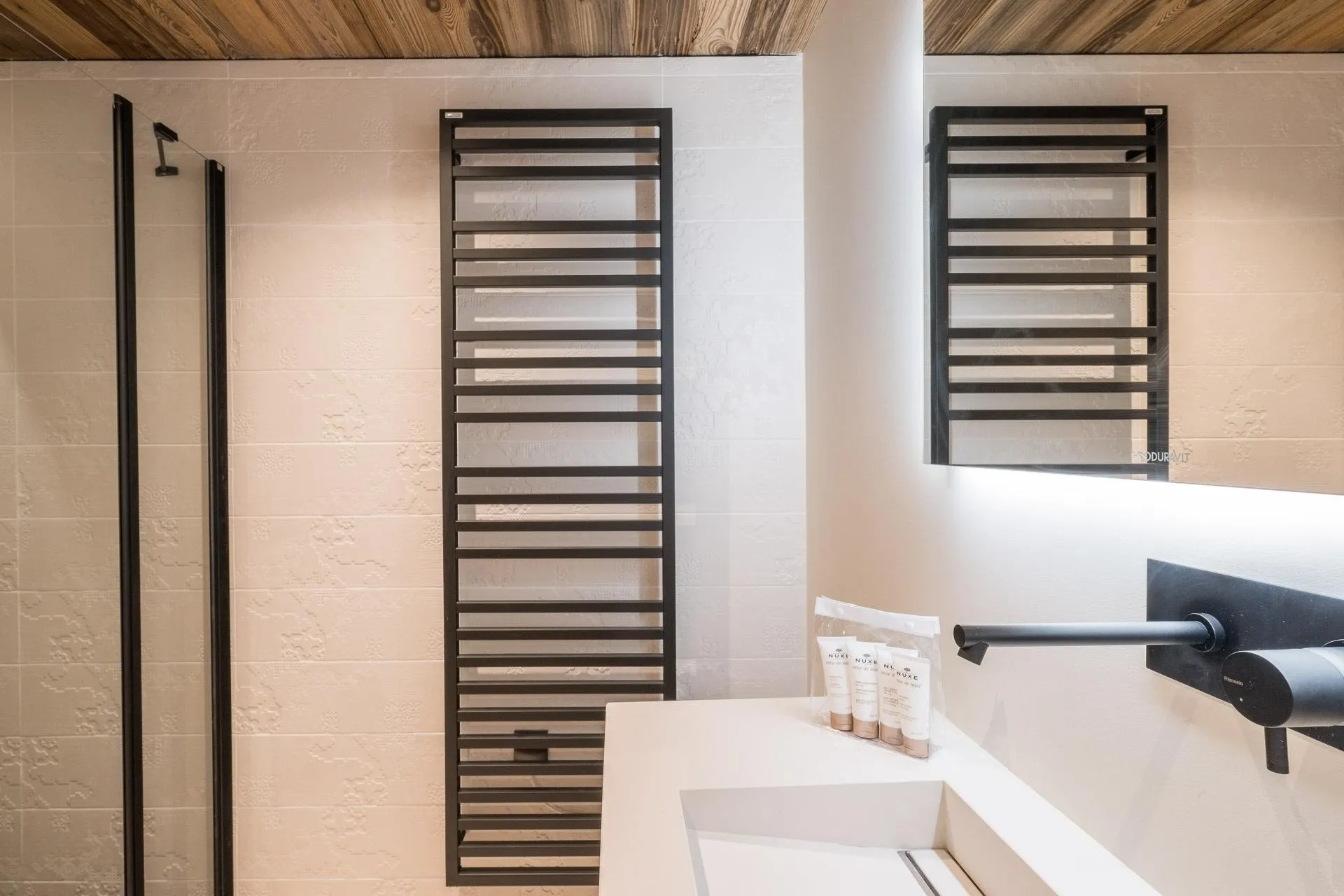 Bathroom with wall-mounted basin tap and towel dryer