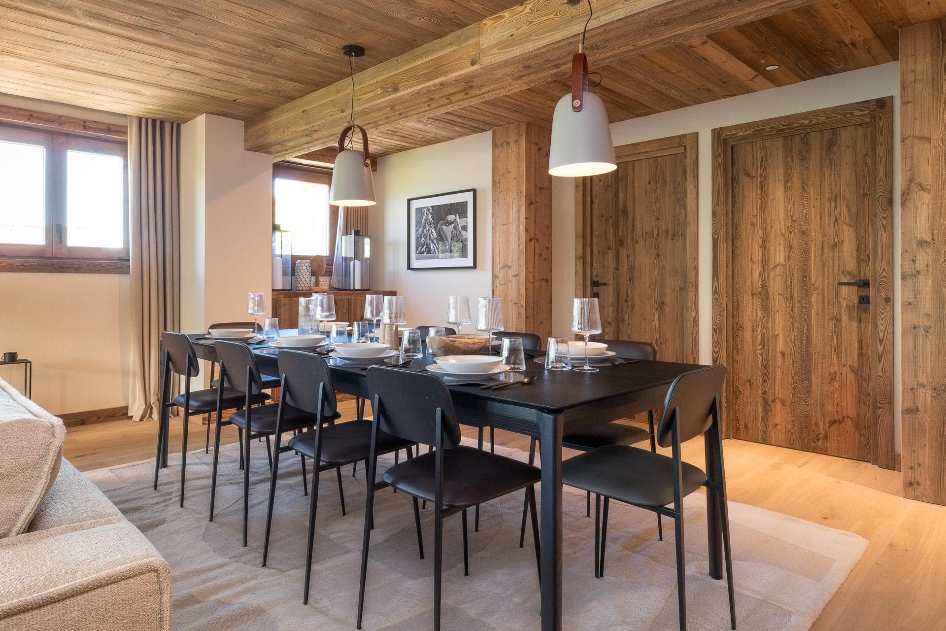 Dining table seats 8 under exposed wood-beamed ceiling