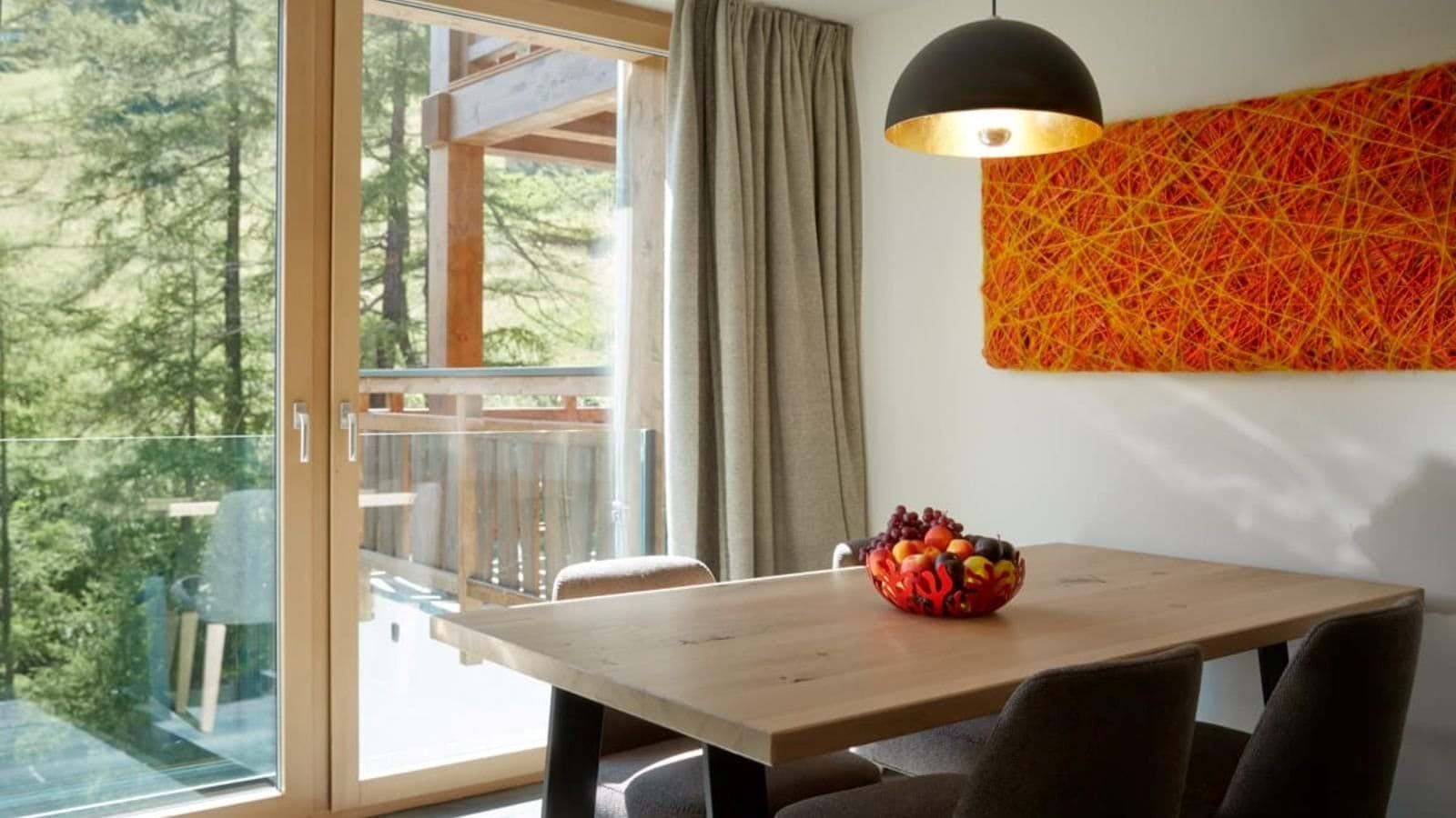Dining area with forest views and sliding door access to balcony