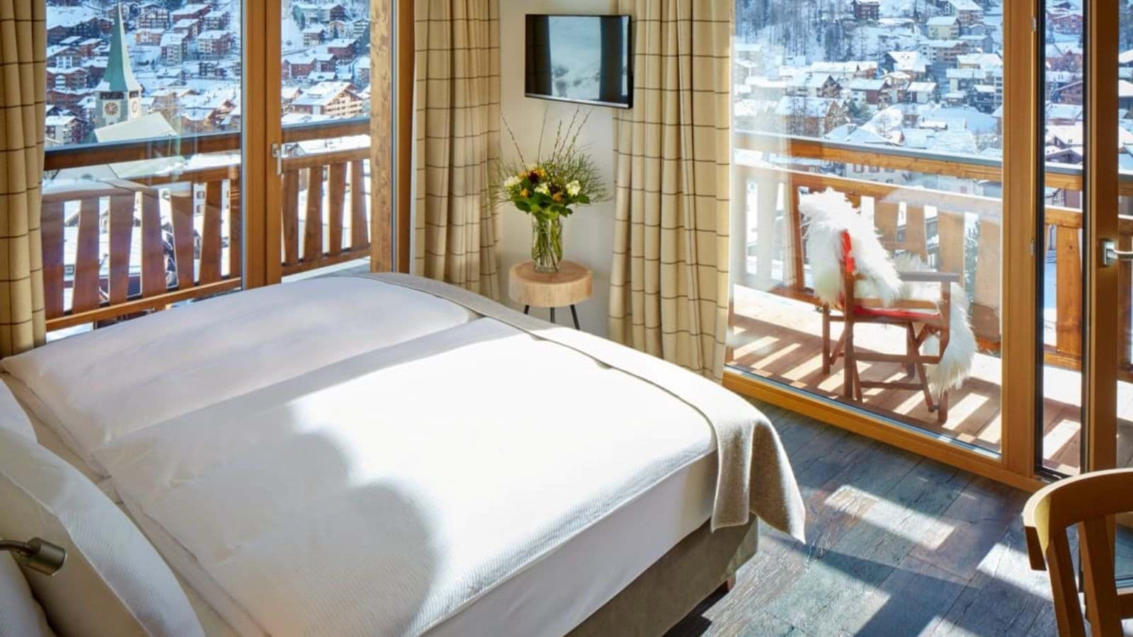 Bedroom with king bed and private balcony overlooking village valley