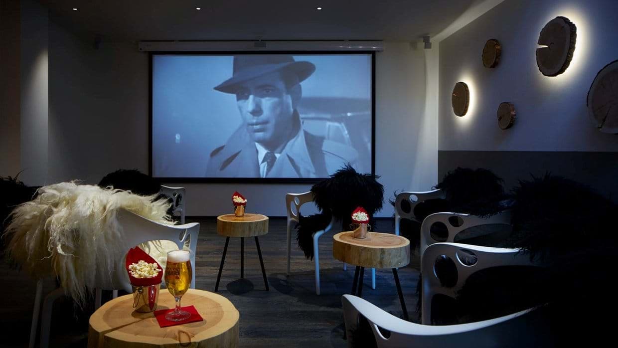 Private cinema with 120-inch projector screen and individual cocktail tables