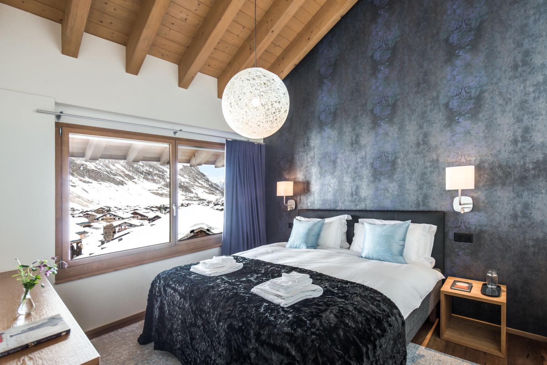 Guest bedroom with king bed and snow-capped mountain views