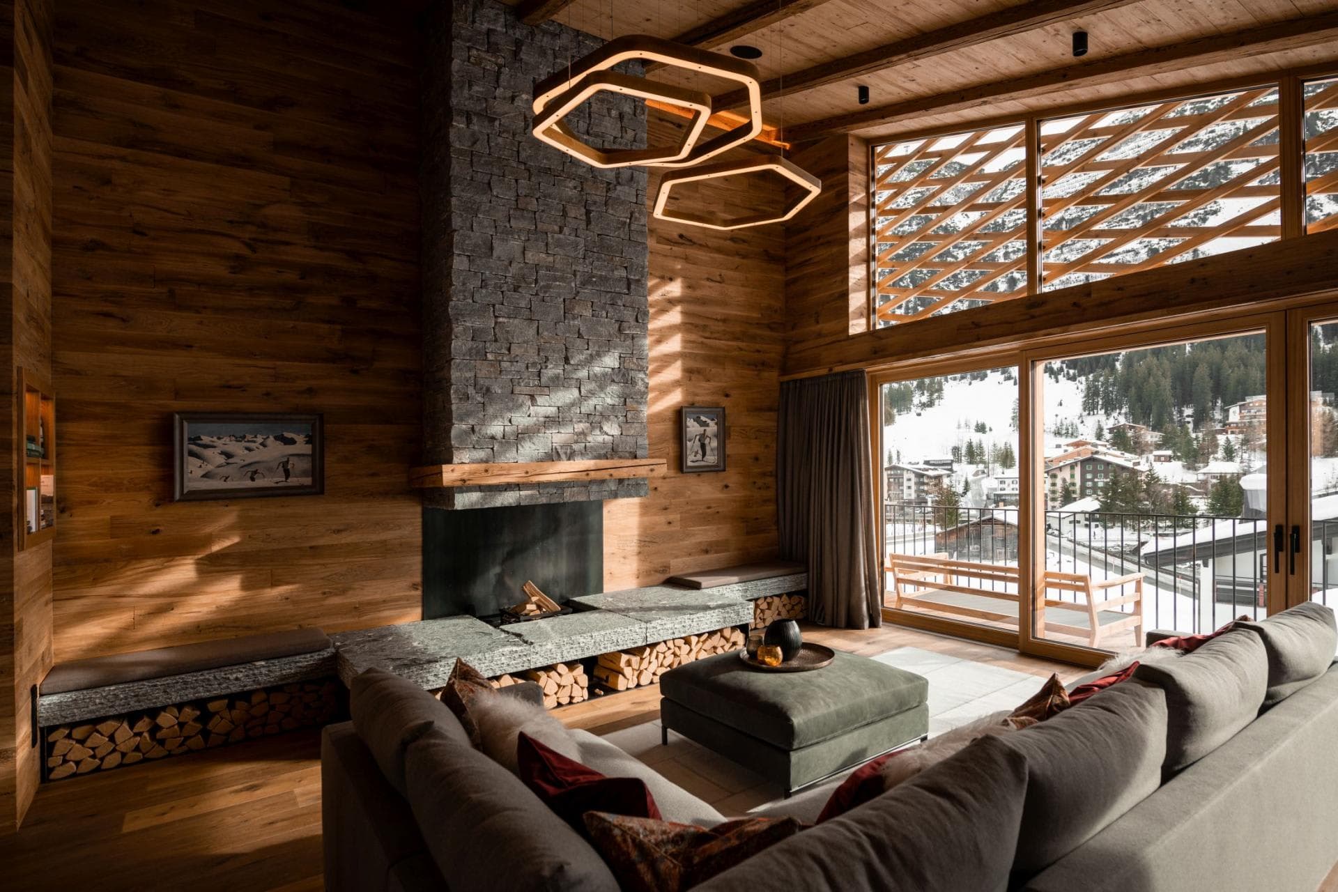 Living area with wood-burning fireplace and balcony overlooking the alpine village