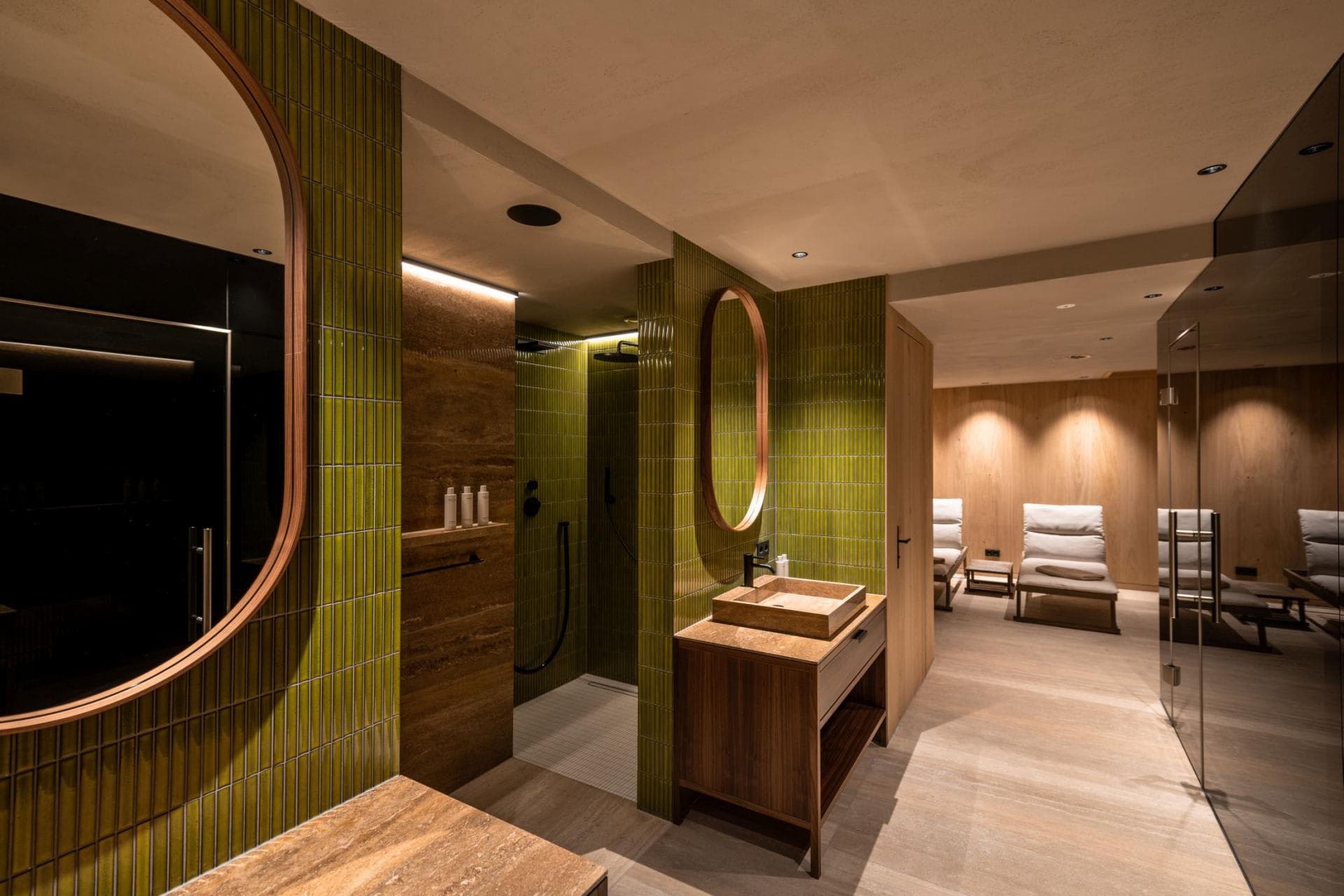 Spa bathroom with walk-in rainfall shower and adjacent relaxation lounge