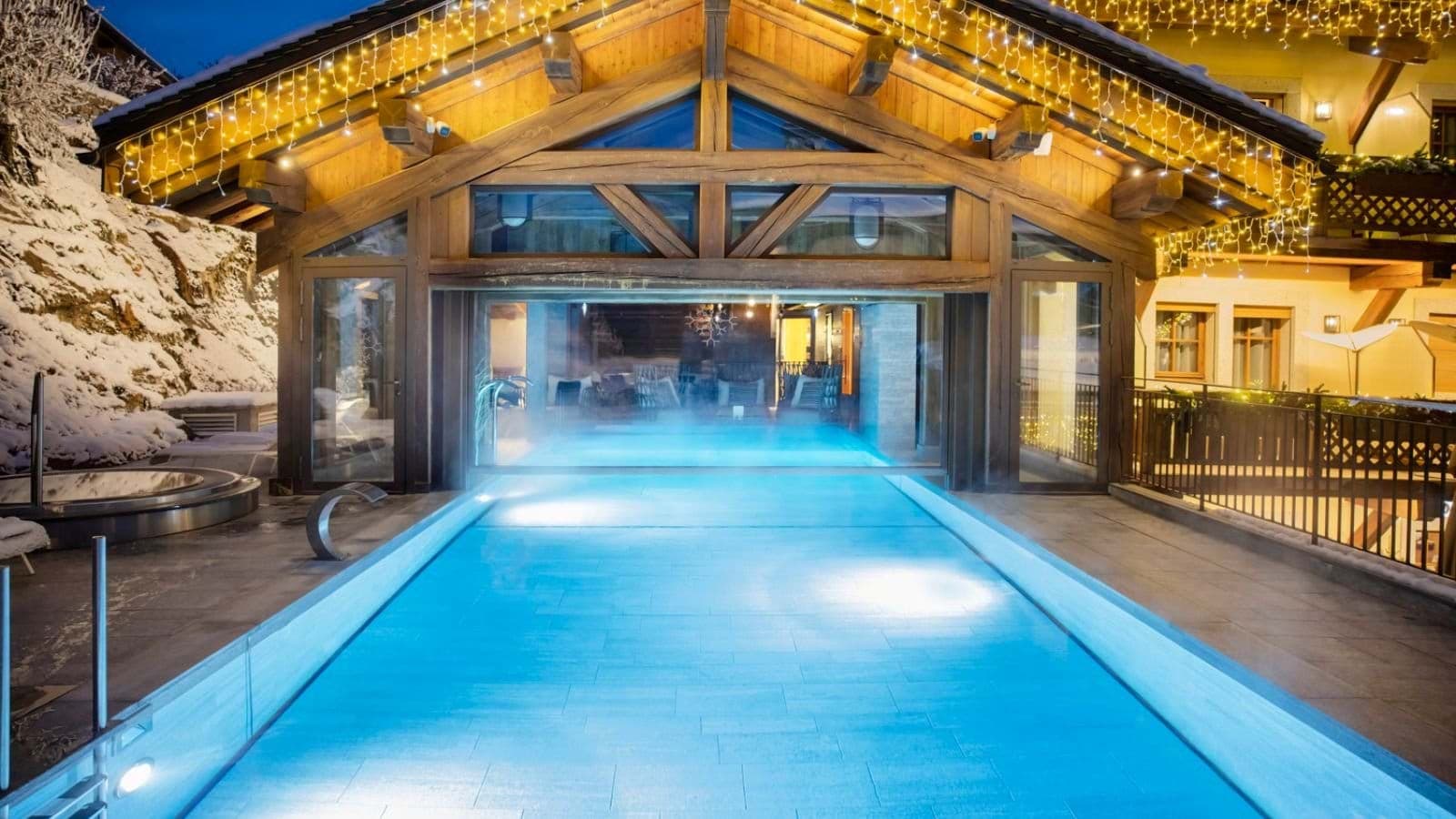 Heated indoor-outdoor connecting pool with adjacent hot tub and mountain views