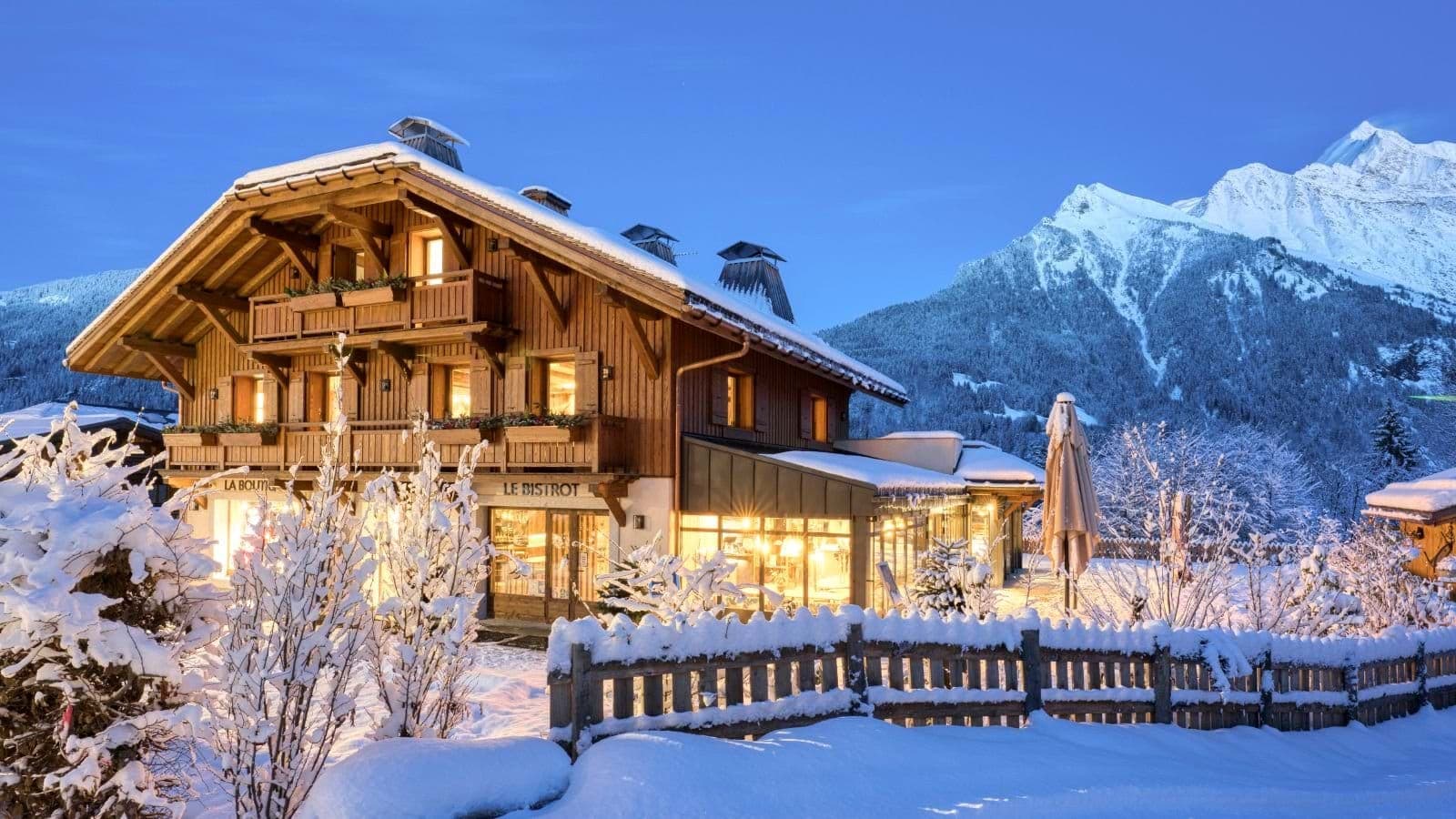 Chalet exterior featuring ground-floor bistro and boutique with mountain backdrop