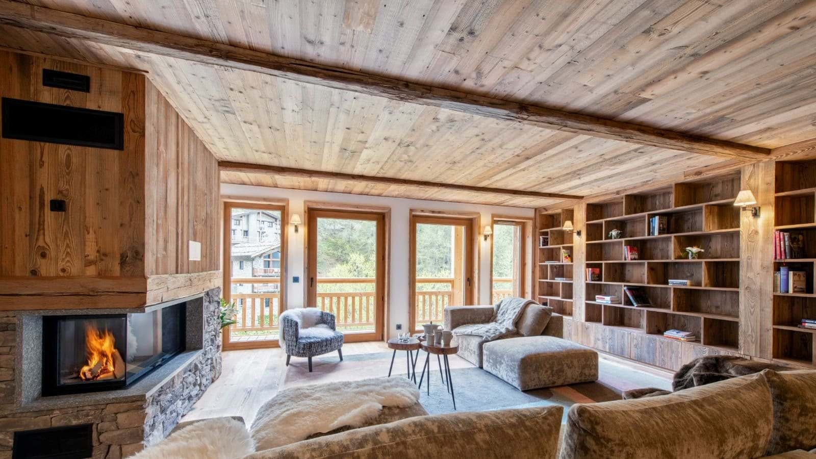 Living room with corner fireplace and floor-to-ceiling library wall