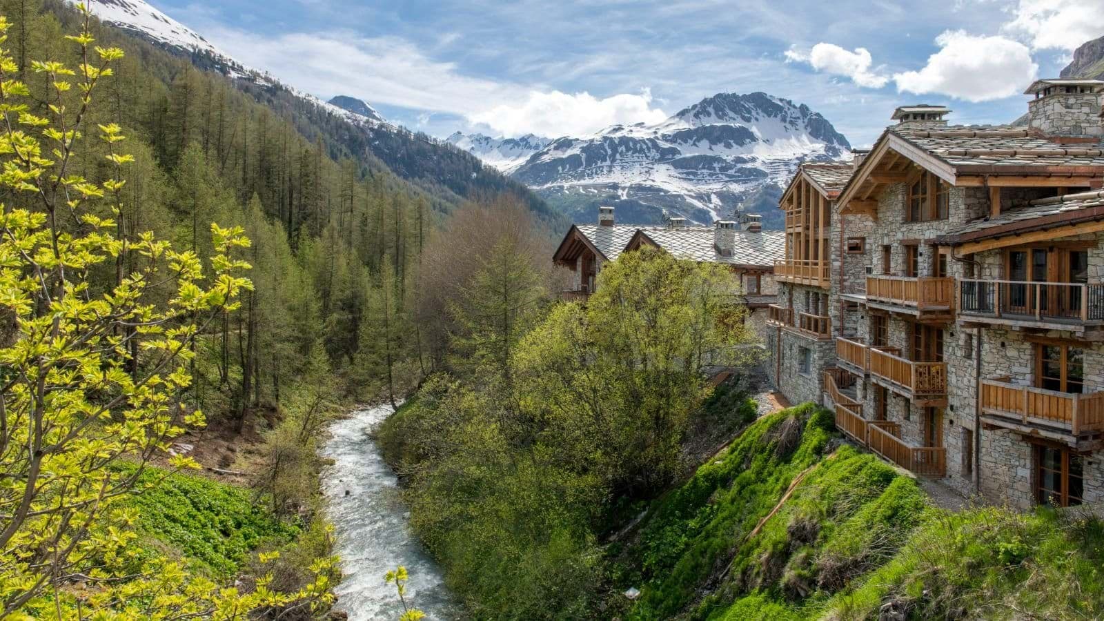 Stone chalets with private balconies overlooking river and mountains