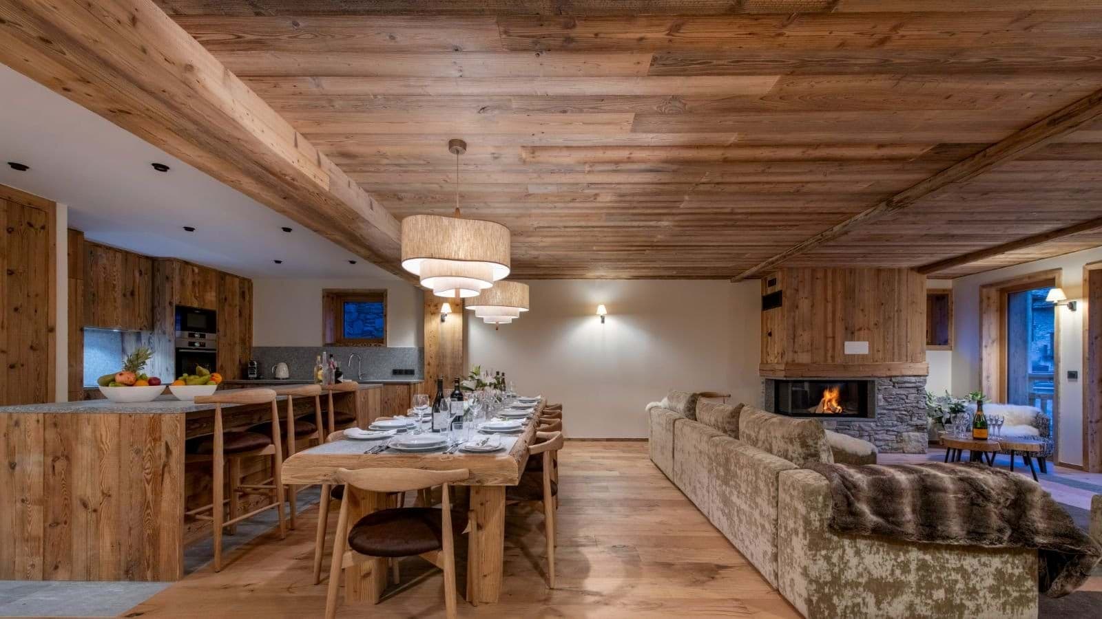 Open living area with wood-burning fireplace and dining table seating 10