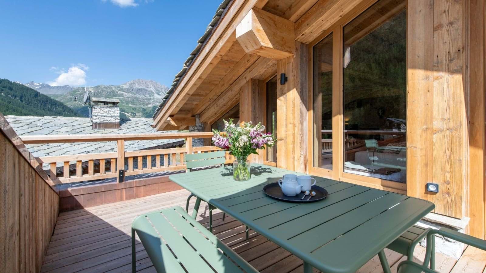 Private balcony with 4-person dining set and mountain views