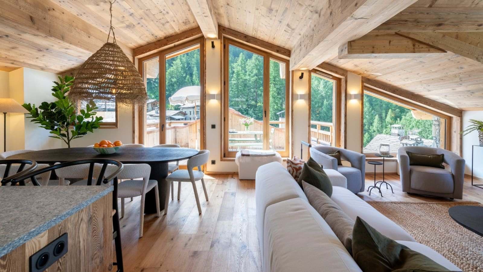 Open-plan living area with vaulted timber ceilings and terrace access