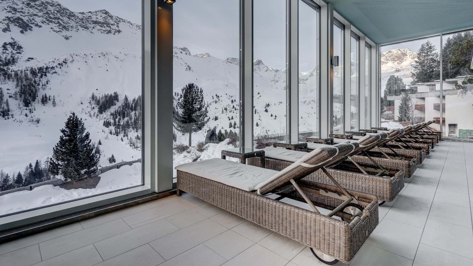 Indoor relaxation lounge with wicker daybeds and mountain valley views