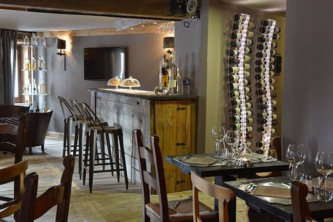 Wine bar and dining area with backlit bottle storage and stool seating