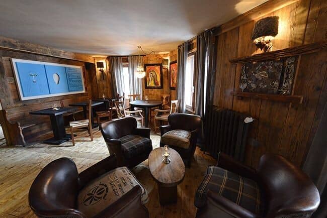 Lounge area with leather club chairs and reclaimed wood paneling