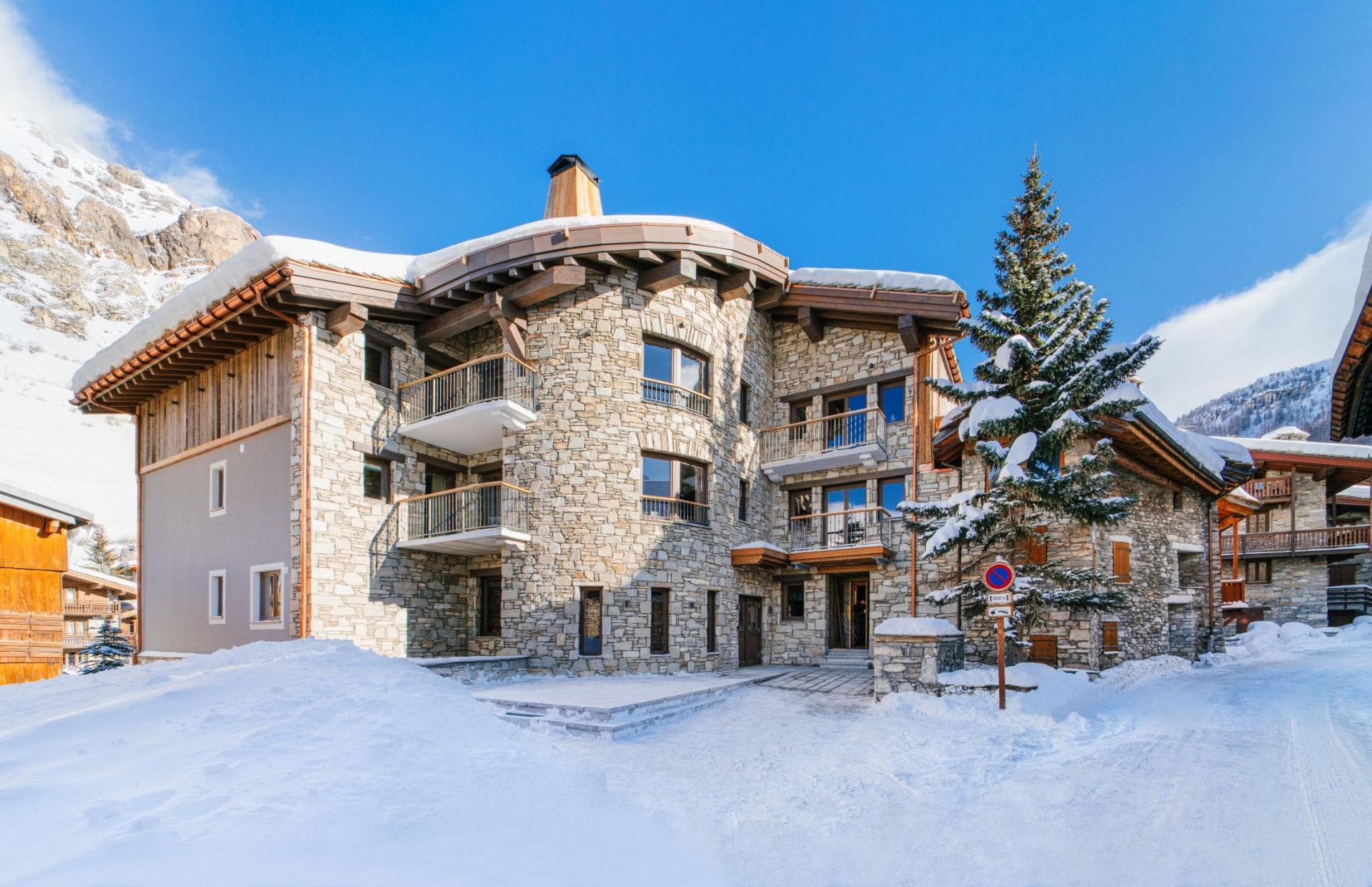 Stone-clad exterior with private balconies and ski-in/ski-out access