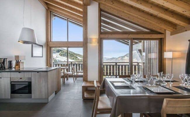 Open-plan dining area and kitchen with mountain views and balcony access
