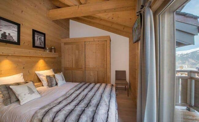 Wood-paneled bedroom with king bed and private balcony access