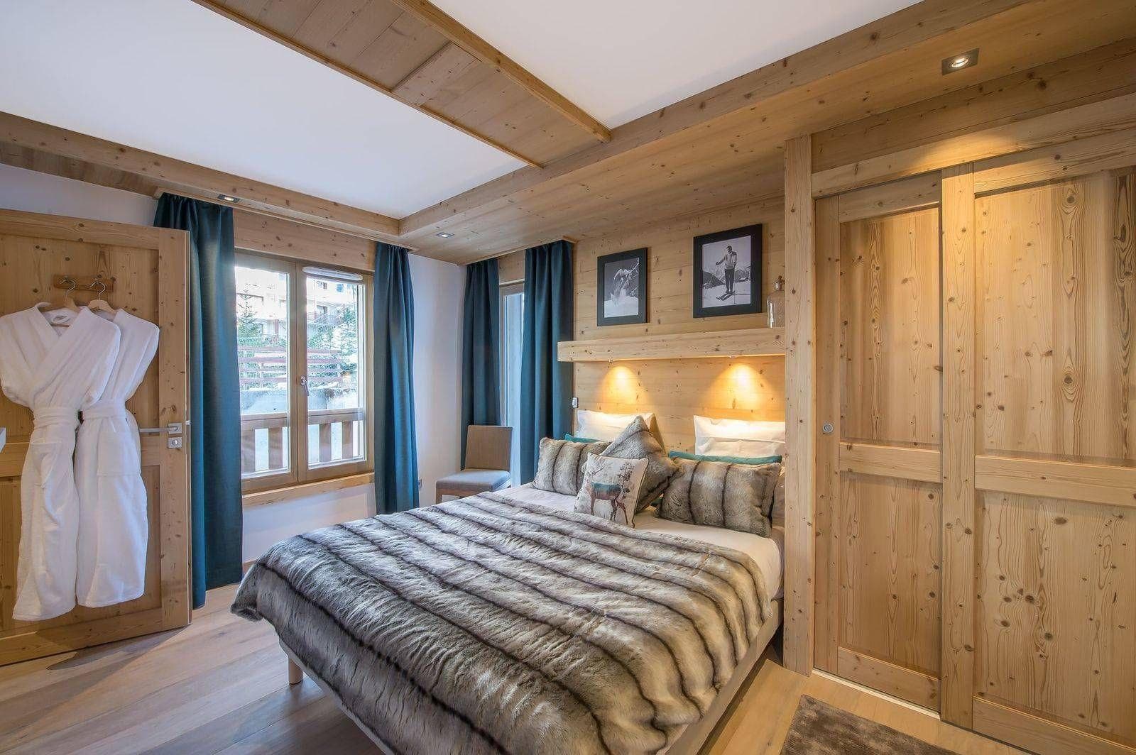 Guest bedroom with queen bed and wood-paneled storage closet