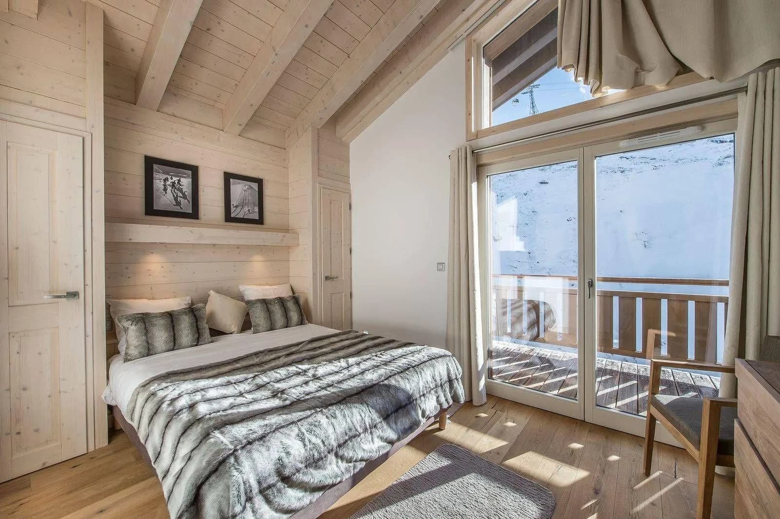 Double bedroom with timber ceilings and balcony access